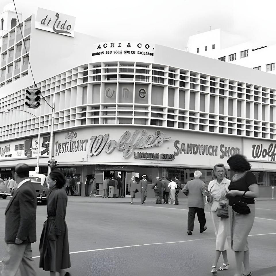 Black and white street view of Wolfie's Restaurant and Sandwich Shop with people walking outside.